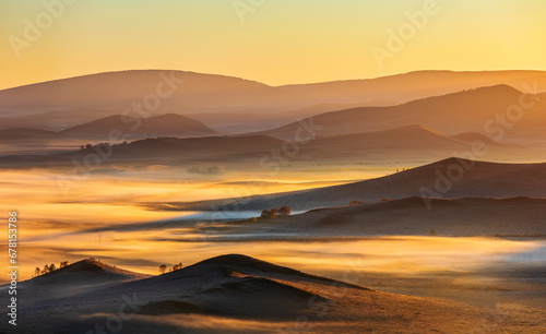 Beautiful mountain range and fog natural landscape at sunrise in Inner Mongolia, China. Grassland natural scenery in autumn season. photo