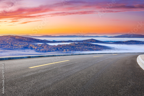 Asphalt highway and mountain with fog natural landscape at sunrise. Road and mountain range nature scenery in autumn season. photo