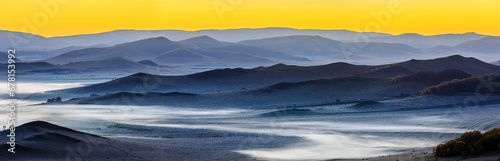 Beautiful mountain range and fog natural landscape at sunrise in Inner Mongolia, China. Grassland natural scenery in autumn season. High Angle view.