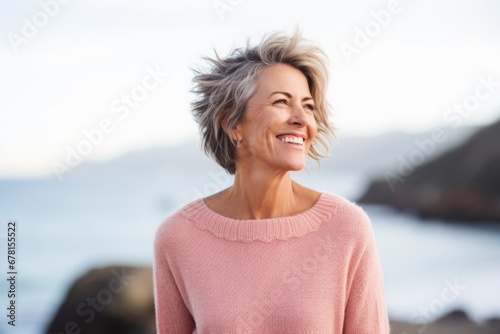Portrait of a joyful woman in her 50s showing off a thermal merino wool top against a tranquil ocean backdrop. AI Generation