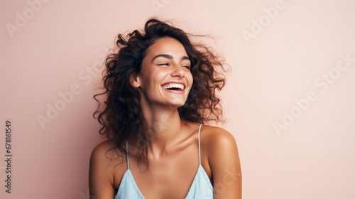 Young beautiful laughing woman against pink background looking aside on copy space 