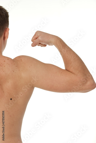 young man showing his bicep over white background. Rear view