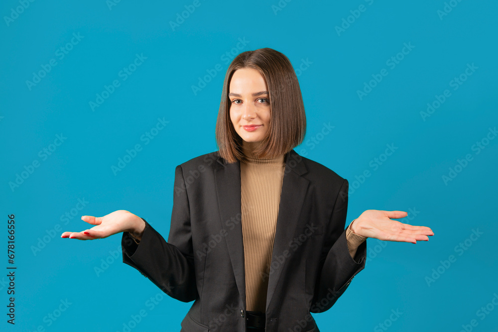 Young woman portrait on blue background. Hands to the sides. Young woman portrait on blue background. Hands to the sides.
