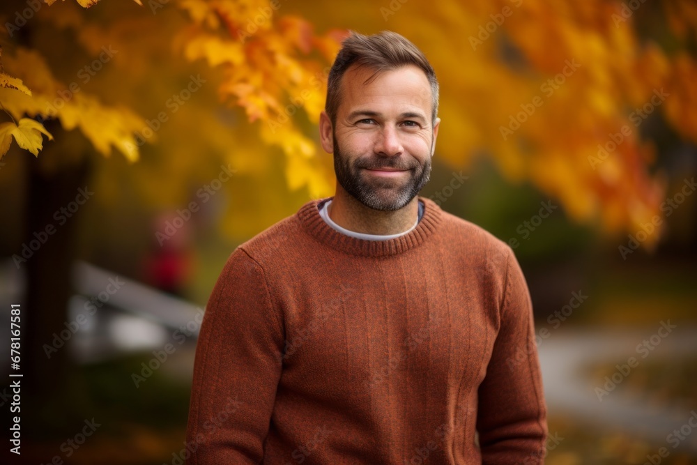 Portrait of a happy man in his 40s wearing a cozy sweater against a background of autumn leaves. AI Generation Portrait of a happy man in his 40s wearing a cozy sweater against a background of autumn leaves. AI Generation