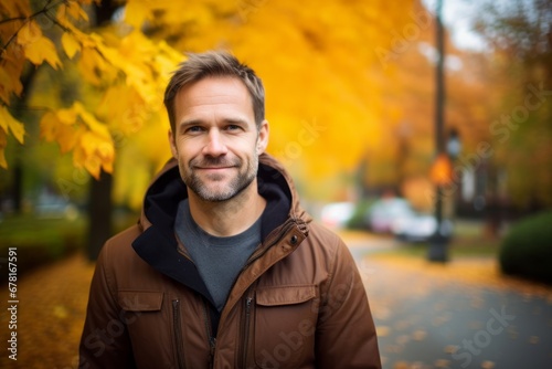 Portrait of a happy man in his 40s wearing a cozy sweater against a background of autumn leaves. AI Generation