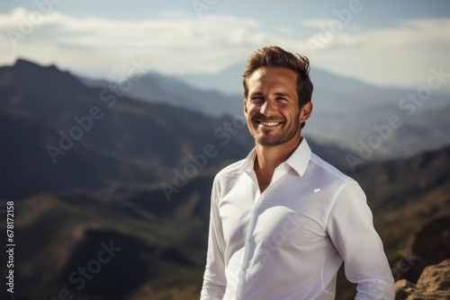 Portrait of a smiling man in his 40s wearing a classic white shirt against a panoramic mountain vista. AI Generation