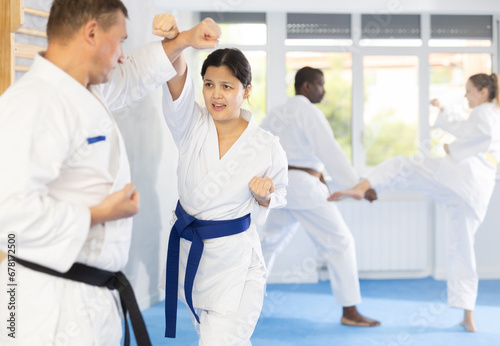 In gym, cosmopolite athletes work in pairs and learn to use classic karate techniques to repel an opponents blow, hone melee skills, strengthen spirit. Sport as lifestyle.