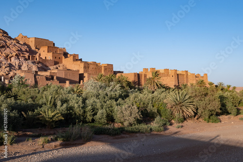 Oasis town of Ait Benhaddou next to an oasis with palm trees in the Moroccan Sahara Desert photo