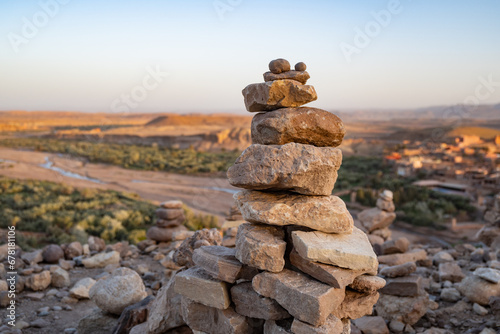 Stack of stone piled up on a hill in the Sahara Desert next to Ait Benhaddou during sunset photo