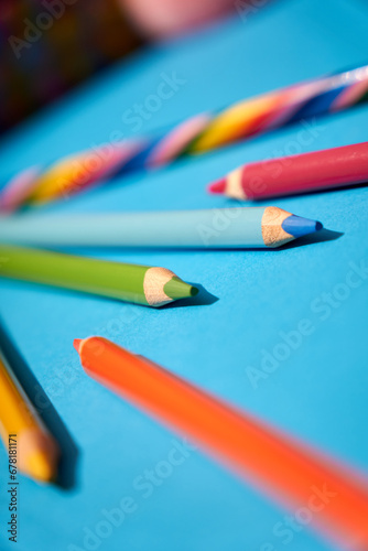 Colorful pencils and crayons on a blue background 