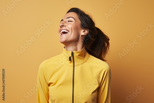 Portrait of a joyful woman in her 30s sporting a technical climbing shirt against a pastel yellow background. AI Generation