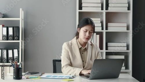 Asian woman sitting in office, businesswoman in finance and accounting is working, collecting financial documents to summarize financial statements, profit and loss statement, accounting concept. photo