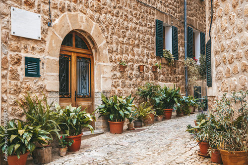 Picturesque street with lots of plants in pots in the village Fornalutx in Mallorca