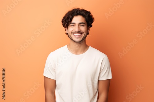 Wallpaper Mural Portrait of a grinning man in his 20s wearing a simple cotton shirt against a pastel orange background. AI Generation Torontodigital.ca