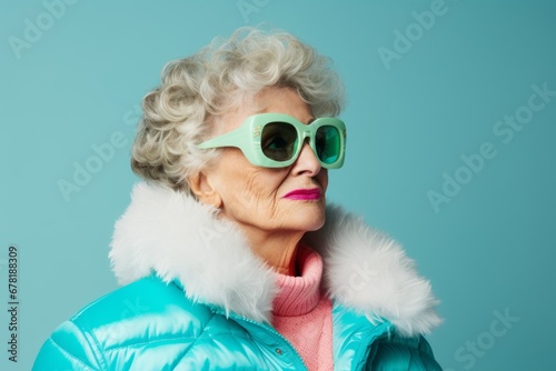 Portrait of a content woman in her 70s dressed in a thermal insulation vest against a pastel teal background. AI Generation © CogniLens