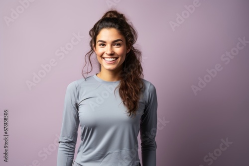 Portrait of a satisfied woman in her 20s sporting a technical climbing shirt against a pastel gray background. AI Generation