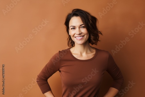 Portrait of a smiling woman in her 30s showing off a thermal merino wool top against a soft brown background. AI Generation