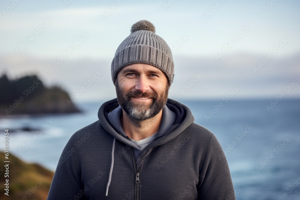 Portrait of a grinning man in his 40s donning a warm wool beanie against a serene seaside background. AI Generation Portrait of a grinning man in his 40s donning a warm wool beanie against a serene seaside background. AI Generation