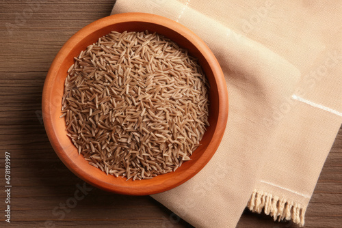 rice in a bowl, Bowl of caraway seeds and napkin on wooden table, top view