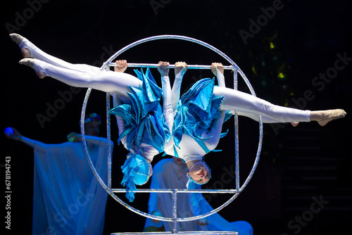 Two acrobat girls show a circus number on a dark background. Acrobatic performance. © Светлана Лазаренко