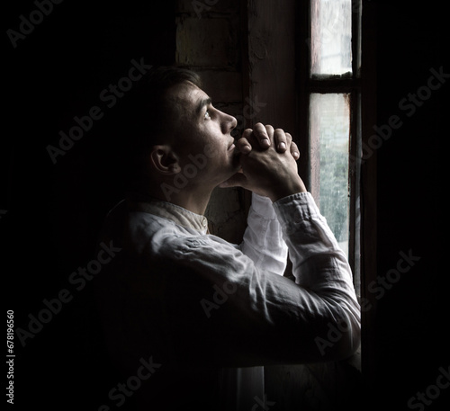 Praying man at the window photo