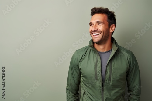 Portrait of a smiling man in his 30s sporting a breathable hiking shirt against a minimalist or empty room background. AI Generation