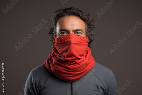 Portrait of a jovial man in his 40s wearing a protective neck gaiter against a minimalist or empty room background. AI Generation