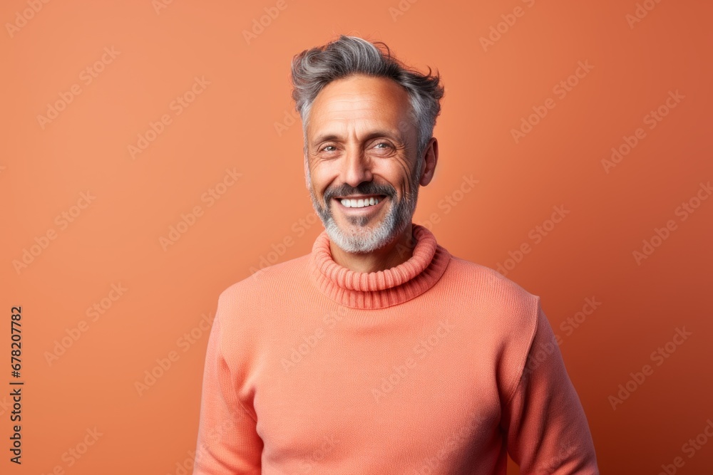 Portrait of a grinning man in his 50s dressed in a comfy fleece pullover against a solid color backdrop. AI Generation