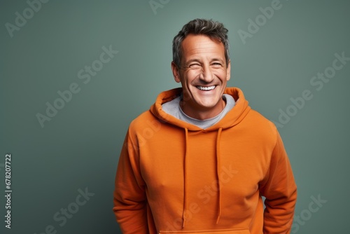 Portrait of a grinning man in his 50s dressed in a comfy fleece pullover against a solid color backdrop. AI Generation © CogniLens