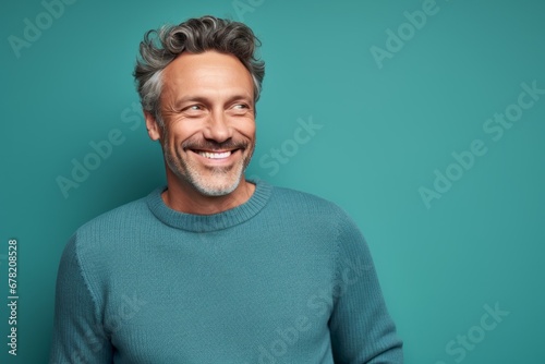 Portrait of a cheerful man in his 40s wearing a cozy sweater against a solid pastel color wall. AI Generation