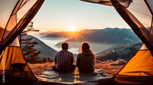 Couple enjoying a vibrant sunrise from a mountain campsite.