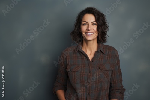 Portrait of a happy woman in her 40s wearing a comfy flannel shirt against a blank studio backdrop. AI Generation