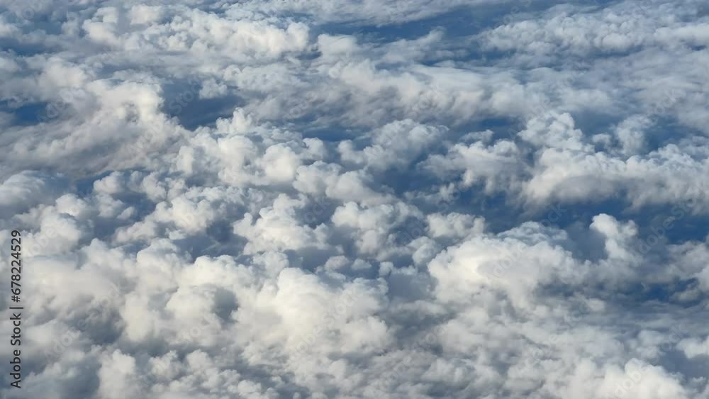View from a plane's window flying over the clouds View from a plane's window flying over the clouds