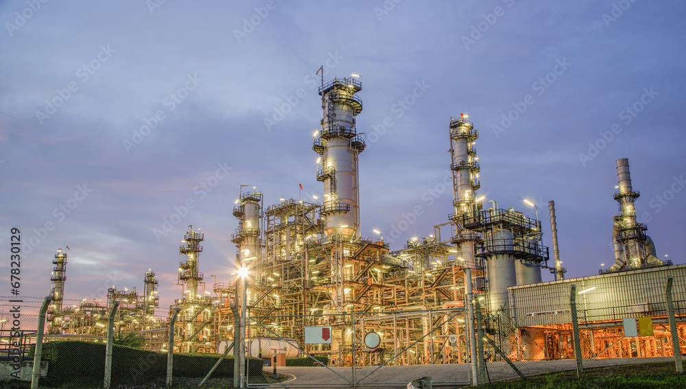 Obraz premium Oil refinery plant from industry zone, Aerial view oil and gas petrochemical industrial, Refinery factory oil storage tank and pipeline steel at night, Ecosystem and healthy environment concepts.