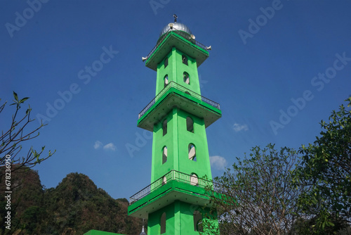 towering green mosque tower © Aidil Diafragma