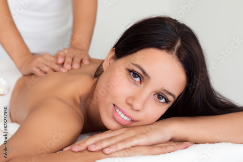 the girl is lying for a massage. a young girl is resting on a massage table under a white towel, the girl is spending time with health benefits