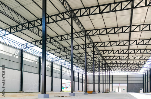 Corrugated steel roof with metal roof beam and columns of new warehouse building structure is under construction in industrial factory area, view from inside and perspective side view