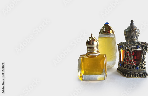 Traditional Arabian glass and decorated attar perfume bottles with gold fragrance, isolated on white copy space. photo