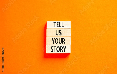 Tell us your story symbol. Concept word Tell us your story on beautiful wooden block. Beautiful orange table orange background. Business tell us your story concept. Copy space.