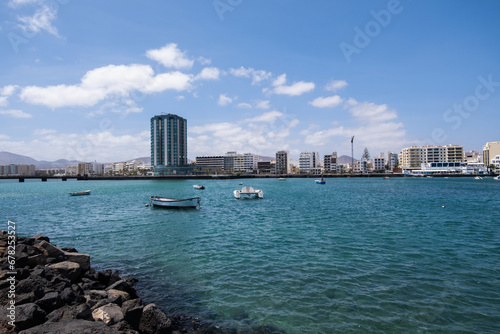 View of the city of Arrecife from the Fermina islet. Turquoise blue water. Sky with big white clouds. Seascape. Lanzarote, Canary Islands, Spain.