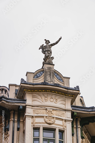 detail of the facade of an important old building with statue with hand extended  © Radu