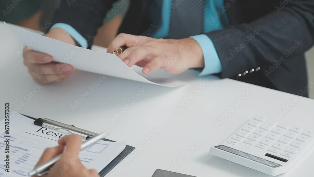 Hands of recruiter holding resume in front of candidate at desk Hands of recruiter holding resume in front of candidate at desk