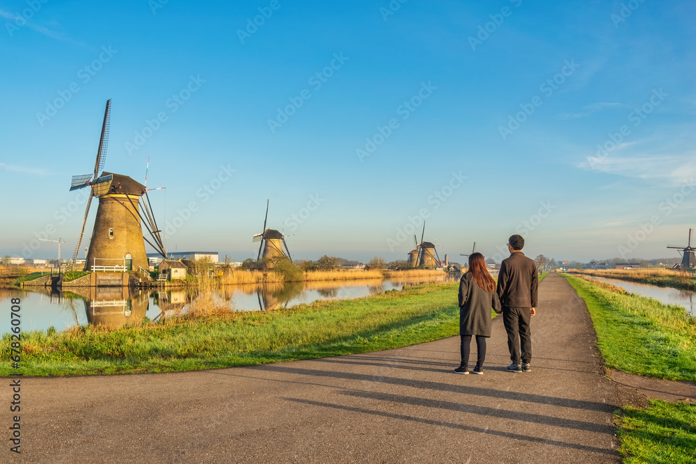 Dutch Windmill landscape at Kinderdijk Village Netherlands with love couple walking