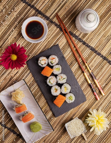 A set of sushi surrounded by side dish, delicious; high quality photo; gourmet products for holiday events closeup view on dinning table natural light copy space