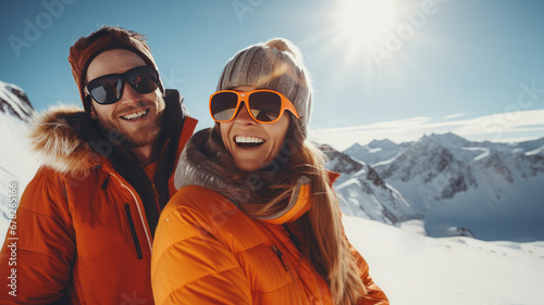 Photo of a happy couple on a snowy mountain.Smiling people, enjoying the sunny weather. Couple goals.