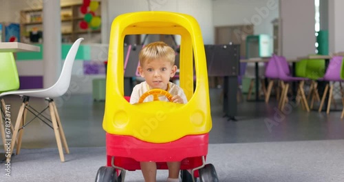 Child boy playing driving toy car indoors playcenter. Educational toys for child photo