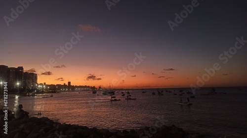 Fototapeta Naklejka Na Ścianę i Meble -  Beachfront twilight in Fortaleza; city lights and azure waves under a soft pink sky