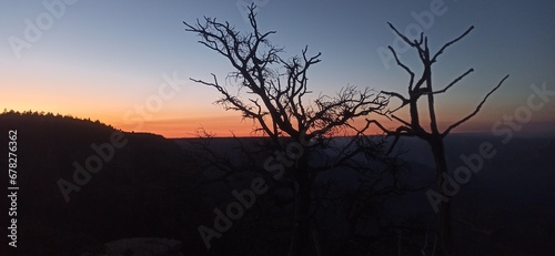 This serene image captures the peaceful transition from day to night at the Grand Canyon, titled "Silhouette of Solitude: Dusk at the Canyon's Edge". 