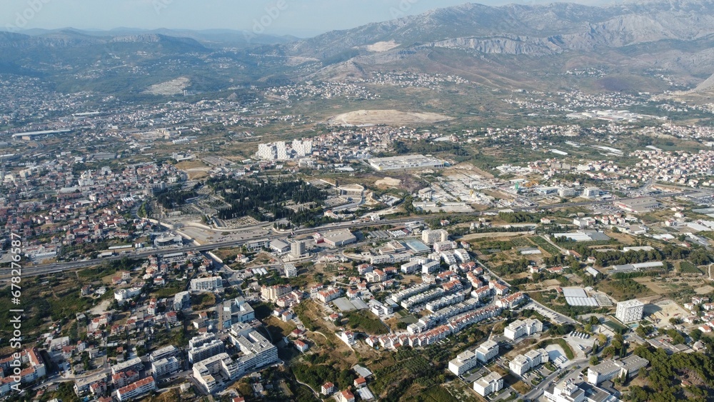 Aerial shot of a town spread around and surrounded by mountains