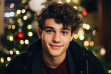 Portrait of a young man on the background of the Christmas tree.